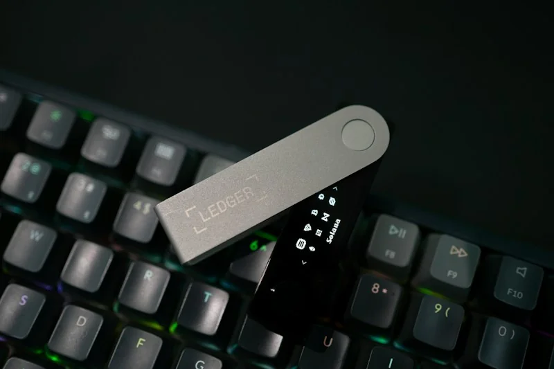 Ledger hardware wallet resting on a computer keyboard.